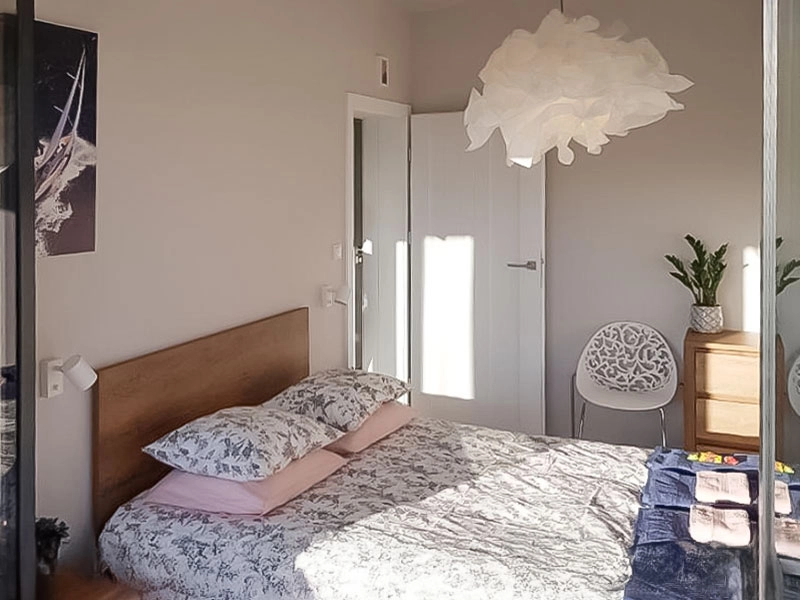 Gemütliches Schlafzimmer im Ferienappartement Dziwnów mit Doppelbett, Tageslicht und stilvoller Einrichtung.