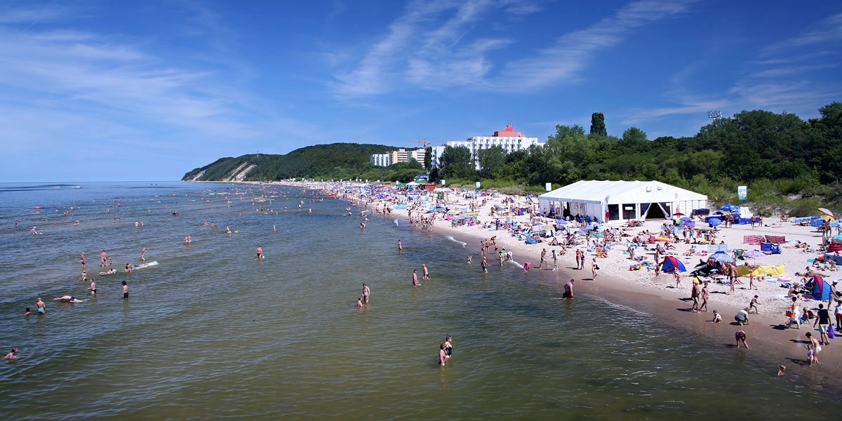 Strand von Misdroy im Sommer mit Badegästen und Eventzelt, Veranstaltungsbereich direkt an der Ostsee.