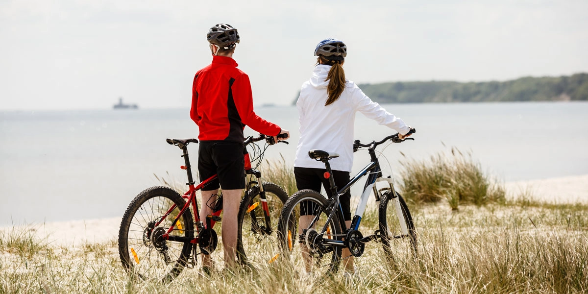 Radfahrer in den Sanddünen von Misdroy mit Blick auf die Ostsee und Küstenlandschaft.