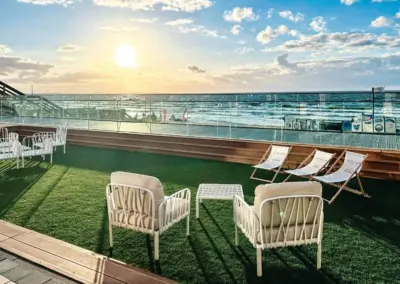 Rückseite der Appartementanlage mit Terrasse für alle Gäste sowie Sitzbereichen.