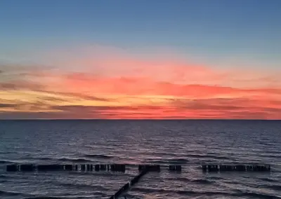 Wunderschöner Sonnenuntergang über der Ostsee in Dziwnów mit ruhigem Meer und farbigem Abendhimmel.