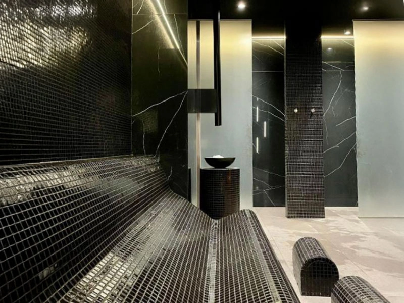 Moderner Wellnessbereich der Appartementanlage in Misdroy mit gefliesten Liegen in der Sauna.