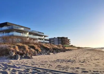 Moderne Ferienanlage in Dziwnów direkt am Sandstrand mit Blick auf die Ostsee bei klarem Himmel.